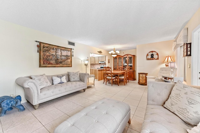 living room featuring light tile patterned floors, a notable chandelier, and a textured ceiling