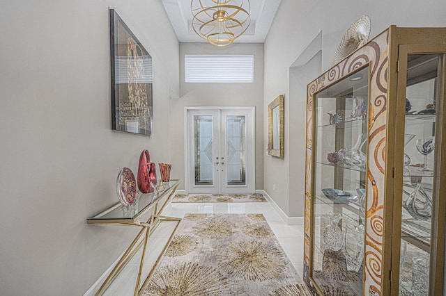 tiled entrance foyer with french doors and a chandelier