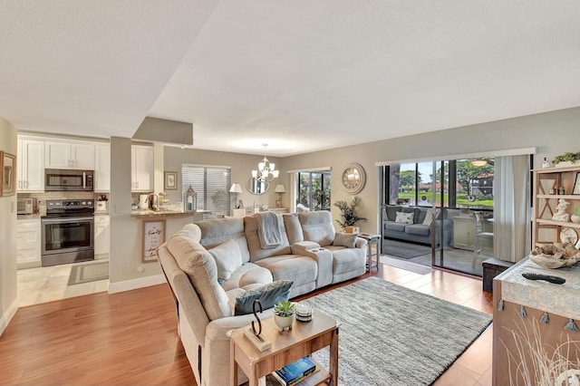 living room featuring a chandelier and light wood-type flooring