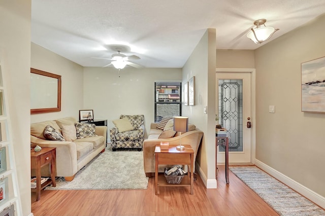 living room with light hardwood / wood-style flooring and ceiling fan