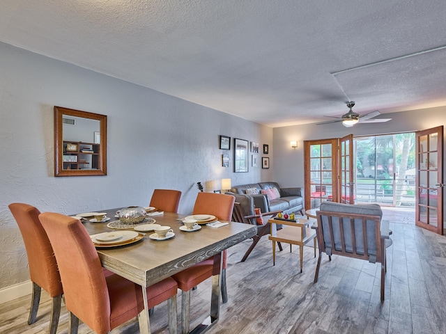 dining space featuring ceiling fan, hardwood / wood-style floors, and a textured ceiling