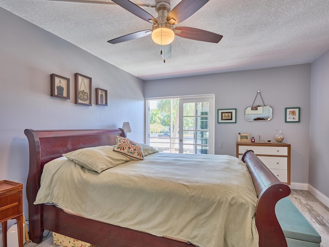 bedroom with ceiling fan, a textured ceiling, and light hardwood / wood-style flooring