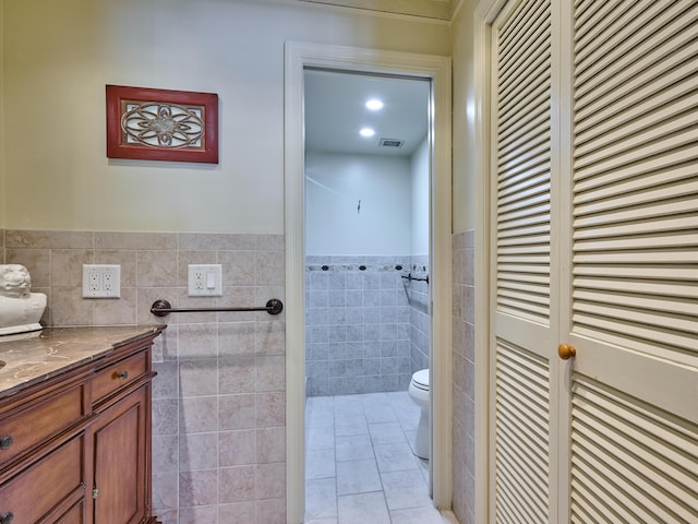 bathroom featuring vanity, tile walls, tile patterned floors, and toilet