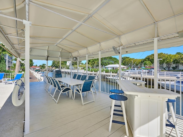 deck with a water view and exterior bar