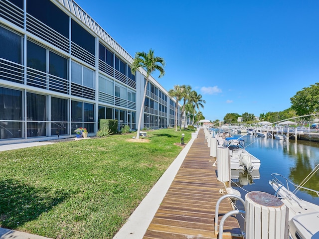 dock area featuring a water view and a lawn