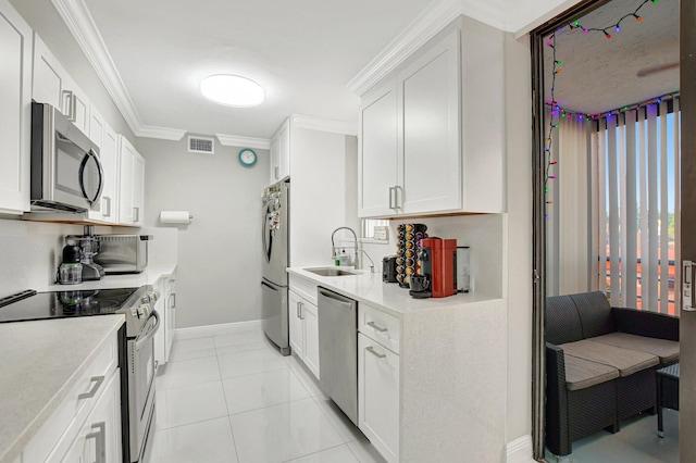 kitchen with light tile patterned flooring, white cabinetry, sink, stainless steel appliances, and crown molding