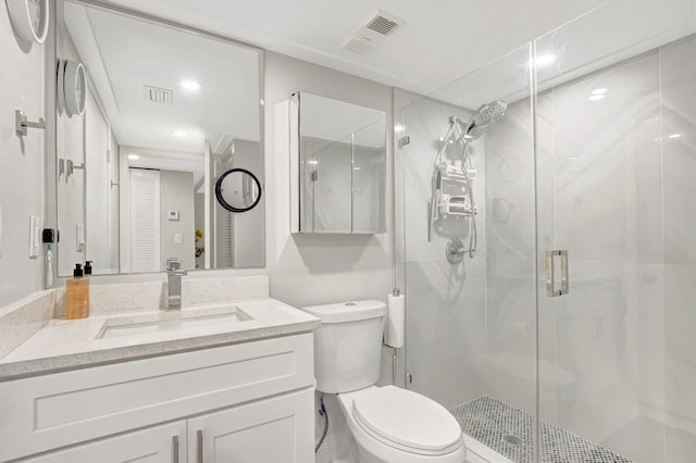 bathroom featuring vanity, walk in shower, and toilet