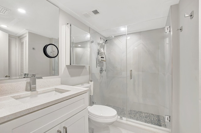 bathroom with vanity, a shower with shower door, and toilet