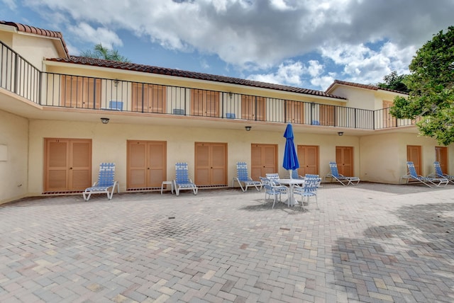 rear view of house featuring a patio area and a balcony