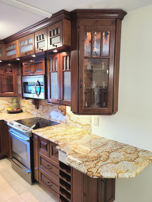 bar featuring light stone countertops, backsplash, stainless steel appliances, and beverage cooler