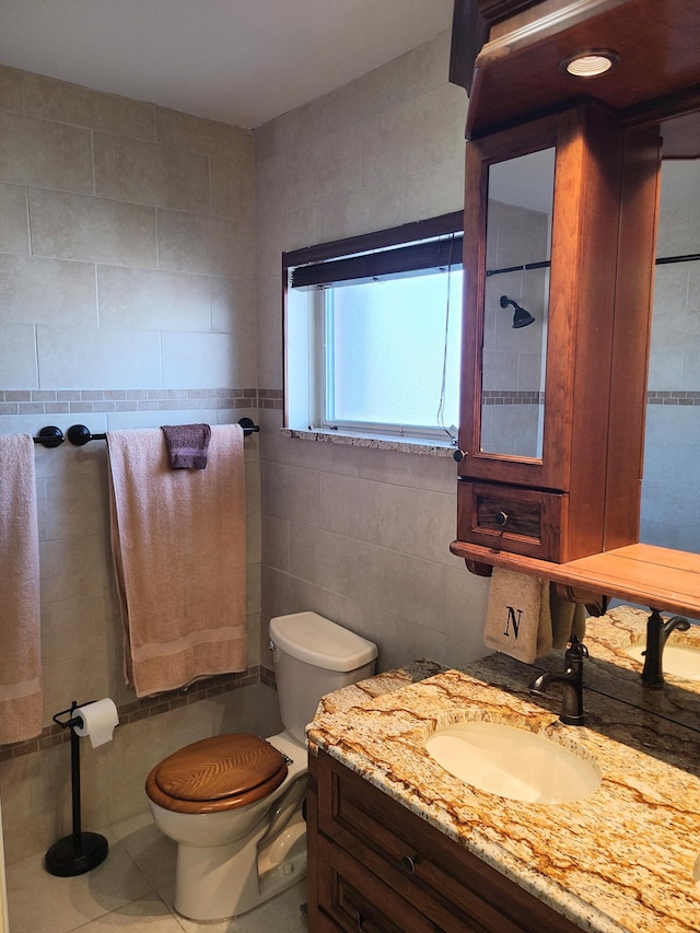 bathroom featuring tile walls, vanity, tile patterned flooring, and toilet