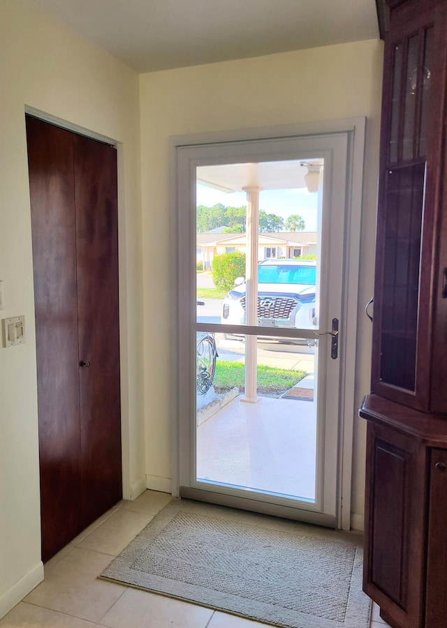 doorway to outside featuring light tile patterned flooring