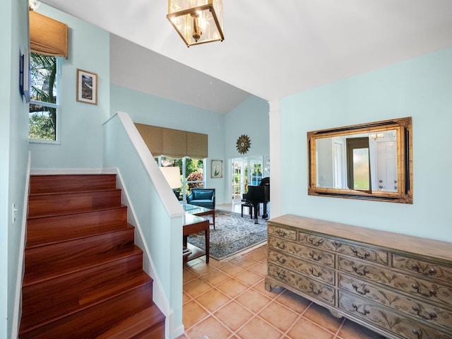 staircase featuring tile patterned flooring and vaulted ceiling