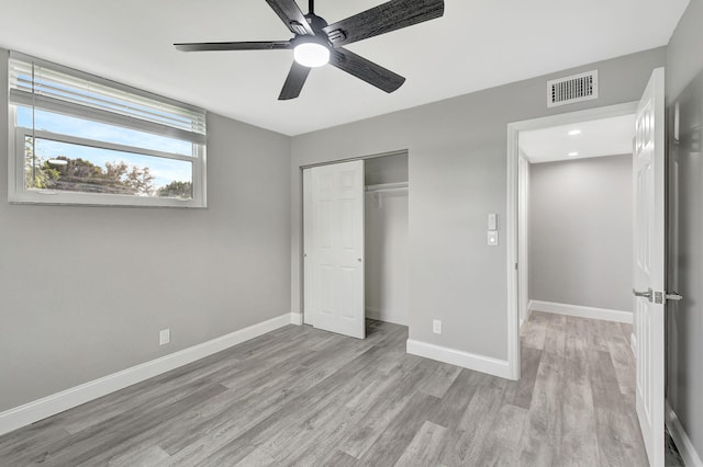 unfurnished bedroom with ceiling fan, light hardwood / wood-style floors, and a closet