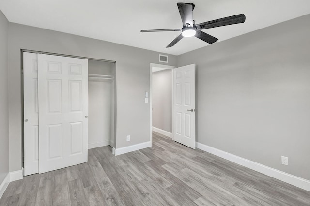 unfurnished bedroom featuring light hardwood / wood-style floors, a closet, and ceiling fan