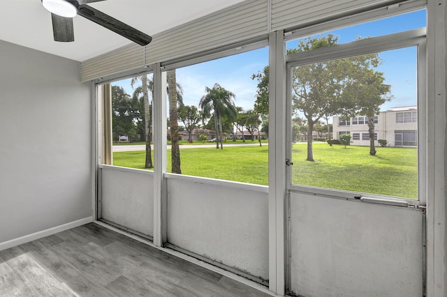 unfurnished sunroom featuring ceiling fan