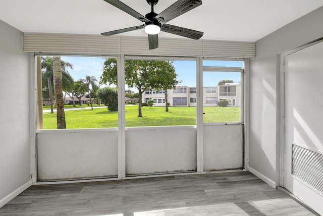 unfurnished sunroom featuring ceiling fan