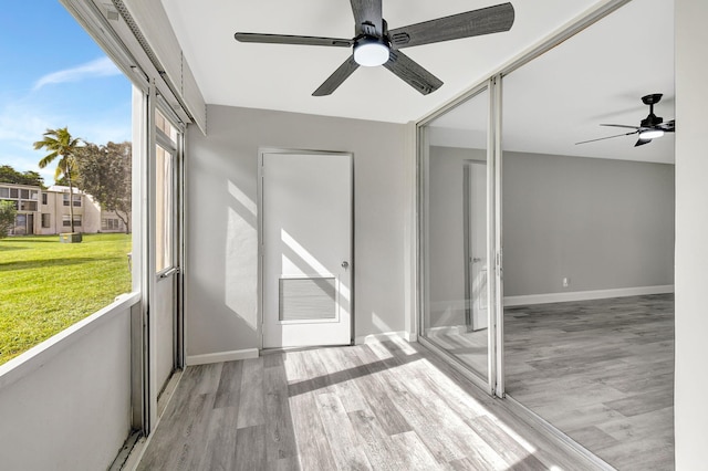 unfurnished sunroom featuring ceiling fan