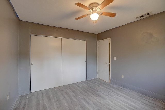 unfurnished bedroom featuring light hardwood / wood-style flooring, a closet, and ceiling fan