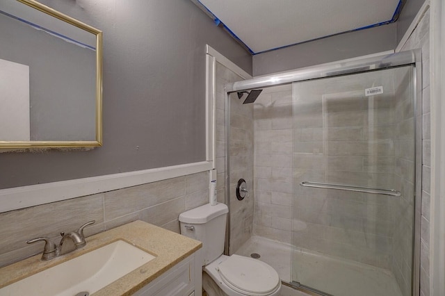 bathroom featuring vanity, tile walls, an enclosed shower, and toilet