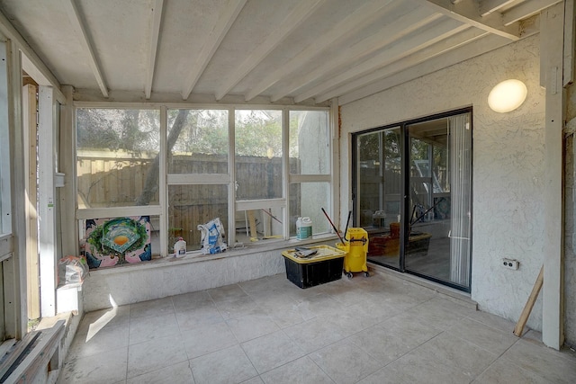 sunroom / solarium featuring beam ceiling