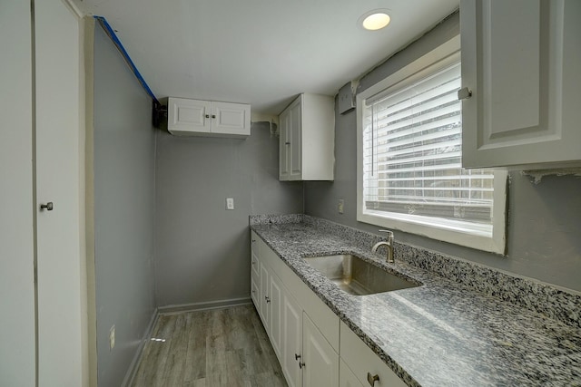 kitchen with white cabinetry, light hardwood / wood-style floors, and sink