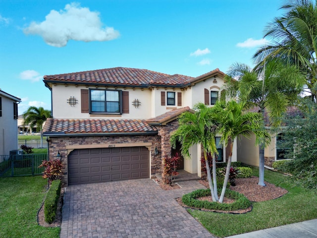 mediterranean / spanish house with a garage and a front lawn