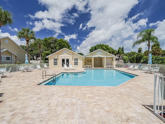 community pool featuring a patio and fence