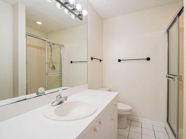 bathroom with toilet, a stall shower, baseboards, tile patterned flooring, and vanity