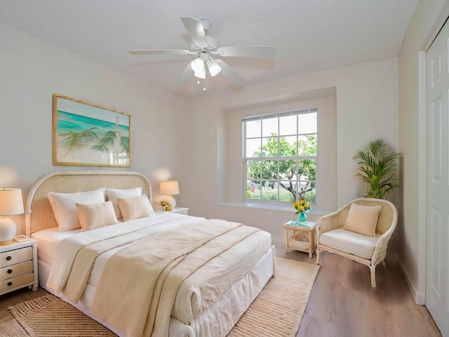bedroom with a ceiling fan, wood finished floors, and baseboards