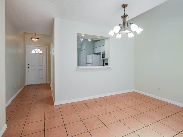 foyer with baseboards, light tile patterned flooring, and a notable chandelier