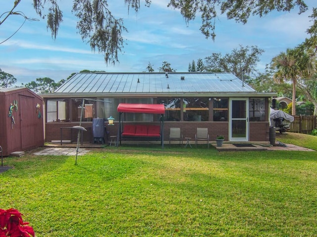 back of house with a yard and a shed