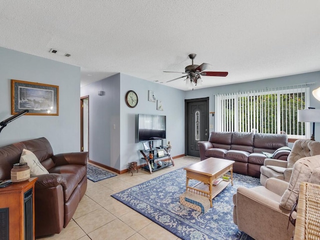 living room with light tile patterned floors, a textured ceiling, and ceiling fan