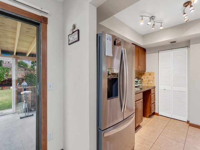 kitchen with stainless steel fridge with ice dispenser, decorative backsplash, and light tile patterned flooring