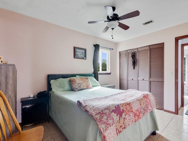 bedroom with light tile patterned floors, a closet, and ceiling fan