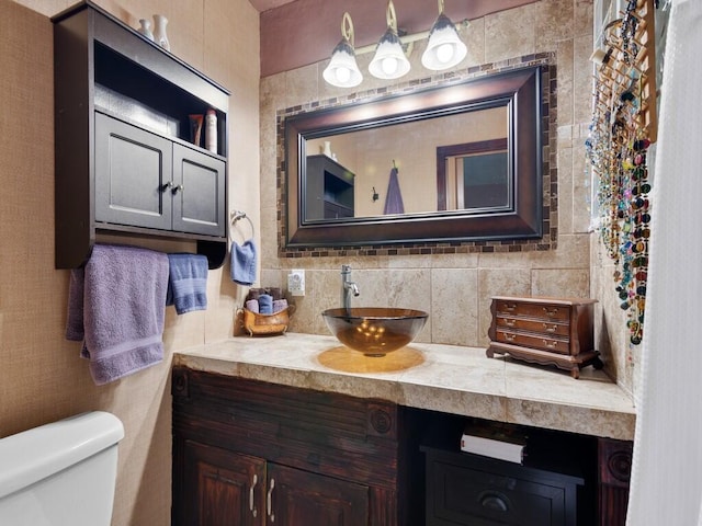 bathroom with vanity, toilet, and decorative backsplash