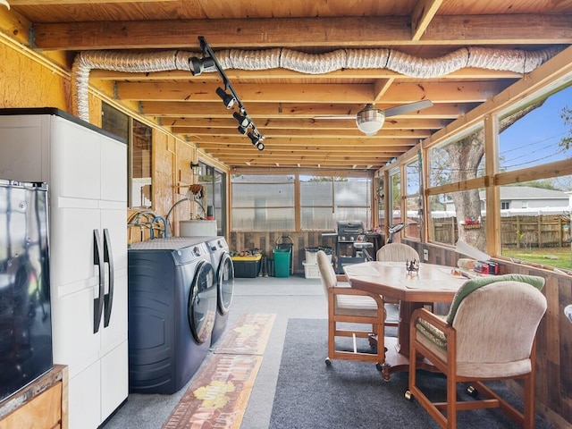 sunroom featuring separate washer and dryer and track lighting