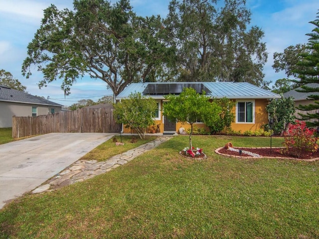 view of front of home with a front yard and solar panels