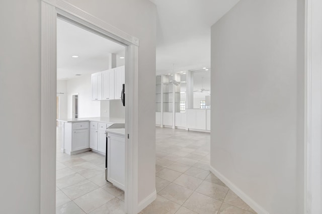 hall featuring light tile patterned floors, baseboards, and recessed lighting