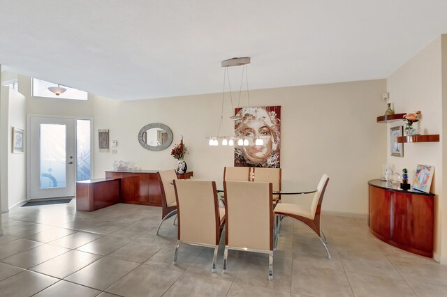 dining area featuring light tile patterned floors, a towering ceiling, and ceiling fan