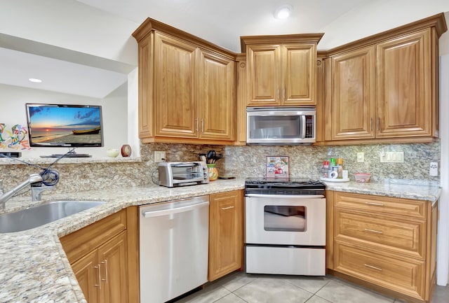 kitchen featuring sink, backsplash, light tile patterned flooring, and appliances with stainless steel finishes