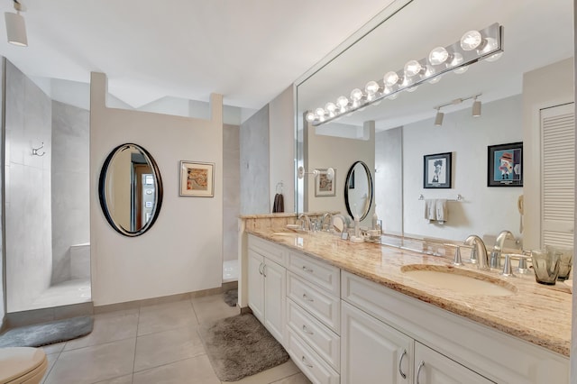 bathroom featuring vanity, tile patterned flooring, and a tile shower