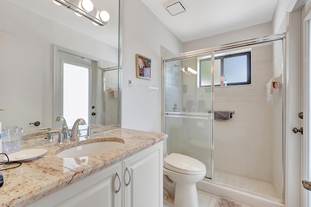 bathroom featuring vanity, an enclosed shower, and toilet