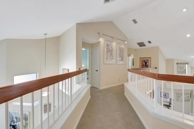 hall with vaulted ceiling and carpet floors