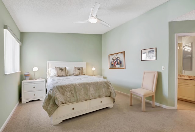 carpeted bedroom with ceiling fan, ensuite bath, and a textured ceiling