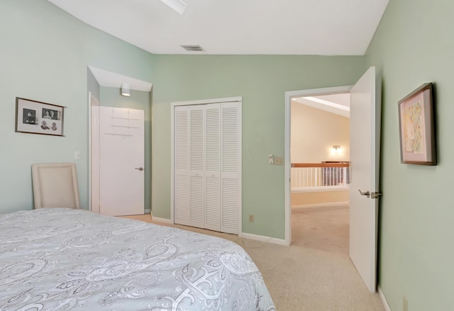 bedroom with vaulted ceiling, light colored carpet, and a closet