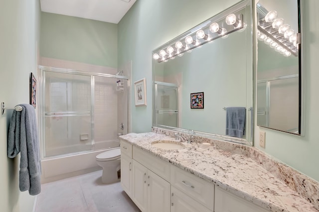 full bathroom with vanity, combined bath / shower with glass door, tile patterned floors, and toilet