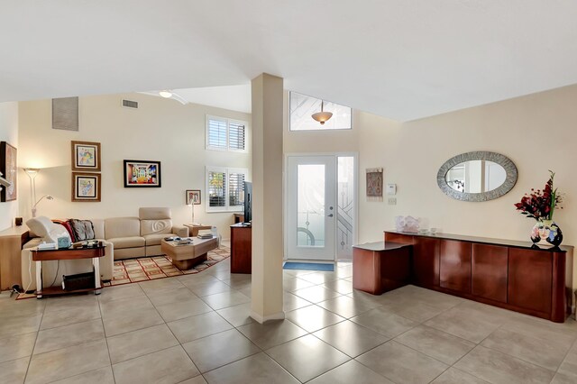 tiled living room featuring high vaulted ceiling