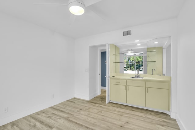 interior space with ceiling fan, vanity, wood finished floors, and visible vents