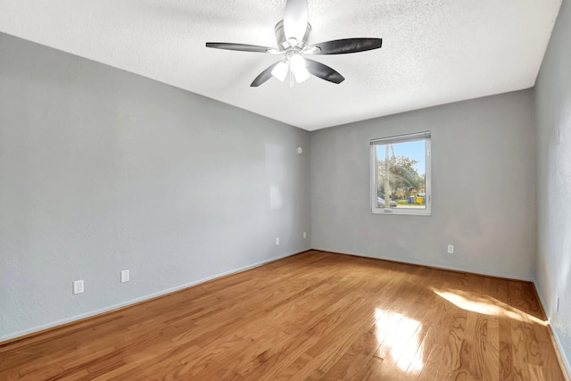 empty room featuring ceiling fan, light hardwood / wood-style flooring, and a textured ceiling